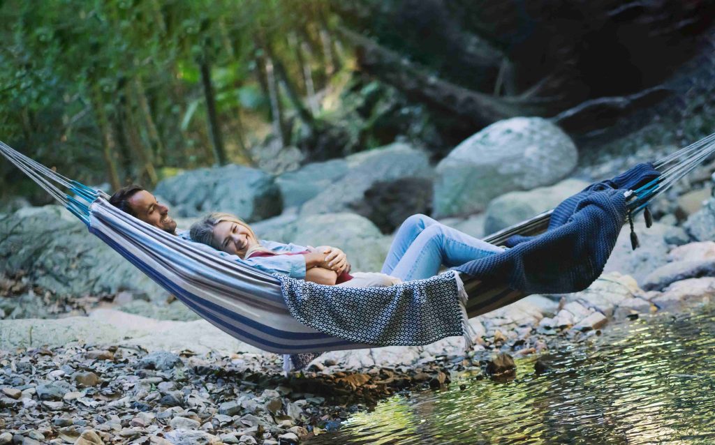 Crystal Creek Rainforest Retreat couple on their honeymoon happy together in a hammock over crystal creek at the eco luxury resort.