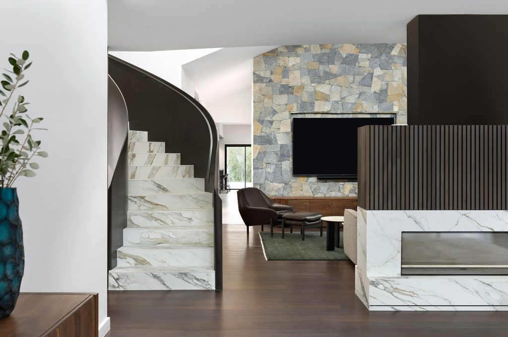 Studio James Interiors - stairs with view of the living or lounging area with a fireplace